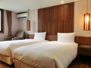 Voodi või voodid majutusasutuse Guide Hotel Taipei Bade toas