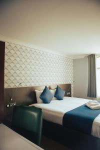 a hotel room with two beds and a chair at Draycote Hotel And Whitefields Golf Course in Rugby