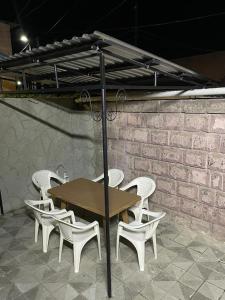 einen Tisch mit weißen Stühlen, einem Tisch und einem Sonnenschirm in der Unterkunft Albus house in Gjumri
