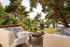 a patio with two white couches and a coffee table at Villa Pueblo in Nafplio