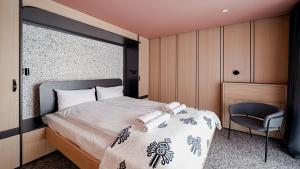 1 dormitorio con 1 cama y 1 silla en Apartamenty Sun & Snow Resorts F Białka Tatrzańska z sauną, en Białka Tatrzanska