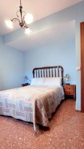 a bedroom with a bed and a blue wall at Vivienda Turística el Ciclamen in Mora de Rubielos