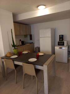 a kitchen with a table and chairs and a kitchen with a refrigerator at Apparteo Perpignan in Perpignan