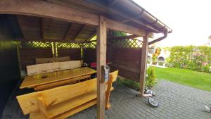 a wooden pergola with a bench on a patio at U BLIŹNIAKÓW pokoje gościnne in Gąski