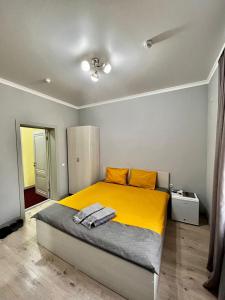 - une chambre dotée d'un grand lit avec des draps jaunes dans l'établissement Мини-гостиница Береке, à Aqtöbe