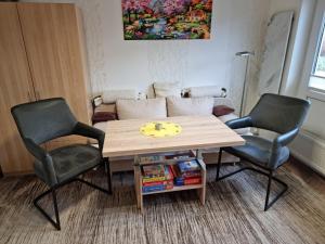 two chairs and a wooden table in a room at Gäth Thomsdorf in Riepsdorf