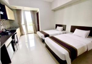a hotel room with two beds and a kitchen at Skyland City Hotel Jatinangor in Cilimus 2