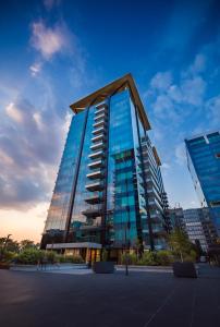 Un edificio alto con ventanas de vidrio en una ciudad. en ONE Luxury Apartments, en Bucarest