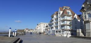 a building on a sidewalk next to the beach at Studio 30 m2 refait à neuf idéalement situé centre ville et plage in Wimereux