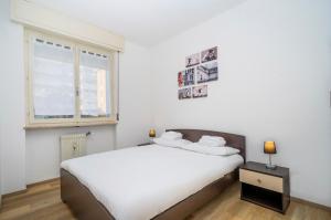 1 dormitorio con cama blanca y ventana en Zia Dina APT - with Balcony, en Pasian di Prato