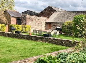 - un jardin avec des chaises et une table en face d'une maison dans l'établissement Cosy Farmhouse Escape in Monmouthshire, à Wolves Newton