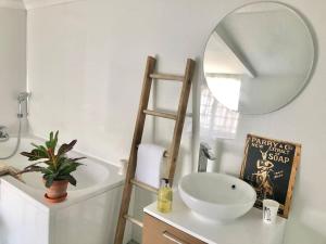 La salle de bains est pourvue d'un lavabo blanc et d'un miroir. dans l'établissement Cosy Farmhouse Escape in Monmouthshire, à Wolves Newton
