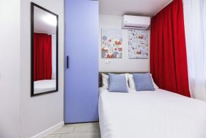 a bedroom with a bed with red curtains and a mirror at MYFREEDOM Апартаменти метро Святошин in Kyiv