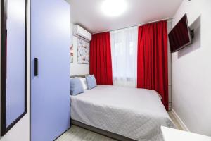 a small bedroom with a bed and a red curtain at MYFREEDOM Апартаменти метро Святошин in Kyiv