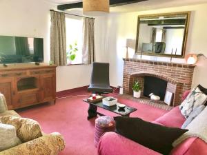 a living room with a couch and a fireplace at Cosy Farmhouse Escape in Monmouthshire in Wolves Newton