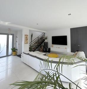 una gran sala de estar blanca con sofá y TV en Villa de standing Piscine privée à 15 min des plages 8VB11, en Perpiñán