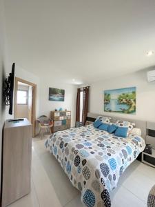 1 dormitorio con 1 cama grande con almohadas azules en Villa de standing Piscine privée à 15 min des plages 8VB11, en Perpiñán