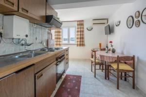 une cuisine avec un évier et une table à l'intérieur dans l'établissement Apartments Vera, à Supetarska Draga