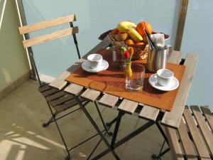 a wooden table with a bowl of fruit and drinks on it at B&B Li Figuli in Lecce