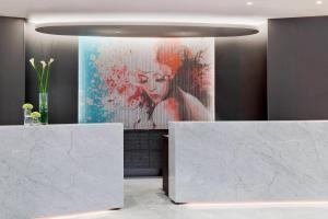 a lobby with a large painting of a woman at Renaissance Wien Hotel in Vienna
