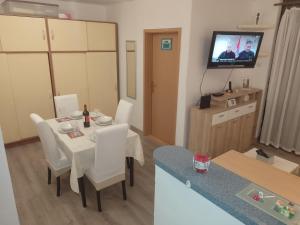 um pequeno quarto com uma mesa e cadeiras e uma televisão em Apartman Ciblja em Velika Gorica