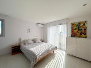 1 dormitorio blanco con 1 cama y una pintura en la pared en Villa de standing Piscine privée à 15 min des plages 8VB11, en Perpiñán