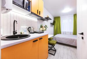 a kitchen with a sink and a bed in a room at MYFREEDOM Апартаменти метро Святошин in Kyiv