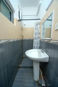 a bathroom with a sink and a window and a shower at Water Front Hotel Kandy in Kandy