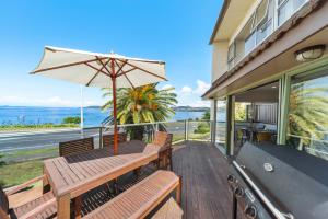 a patio with a table and an umbrella at Lakeside Terrace - Taupo Holiday Home in Taupo