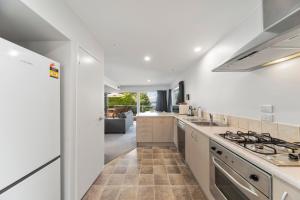 a kitchen with white walls and a stove top oven at Lakeside Terrace - Taupo Holiday Home in Taupo