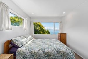 a bedroom with a bed and a large window at Lakeside Terrace - Taupo Holiday Home in Taupo