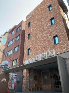 a red brick building with a hotel sign on it at Hotel Daisy in Seoul