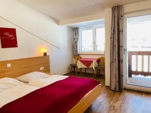 een hotelkamer met een bed en een raam bij Pension Leamhof in Hopfgarten im Brixental