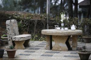 un tavolo in pietra e una panca con tavolo e sedie di KEN & TWILL a Shillong