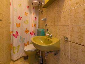een badkamer met een wastafel, een toilet en een douchegordijn bij Apartments Melita in Dramalj
