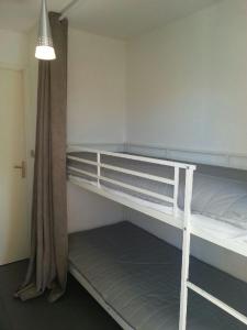 Pokój z 2 łóżkami piętrowymi i lampką w obiekcie ANTINEA Joli T2 cabine piscine proche plage Richelieu cap d'Agde w Cap d'Agde +7 zdjęć
