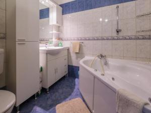 a bathroom with a tub and a sink and a toilet at Apartments Adrasteja in Dramalj