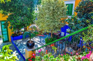 a balcony with a bunch of plants and flowers at Symi Garden Studios in Symi