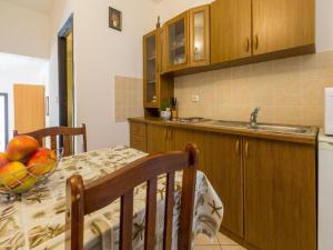 a kitchen with a table with a bowl of fruit on it at Apartments Adrasteja in Dramalj