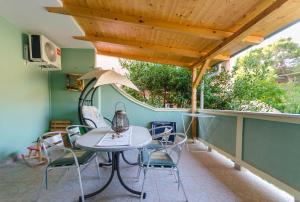 patio ze stołem i krzesłami na balkonie w obiekcie Apartments Ruzica w mieście Banjol