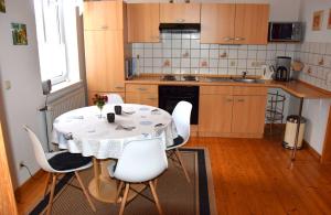 a kitchen with a table and chairs and a table and a kitchen at Haus Sonnenblick in Benneckenstein