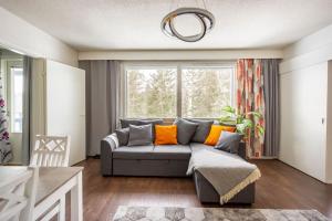 a living room with a couch and a window at Valoisa huoneisto jossa erinomaiset vuoteet. in Mikkeli