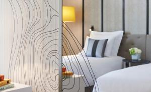 فندق رينسانس باريس لا ديفانس في بيتّو: غرفة نوم بسرير وطاولة مع مصباح