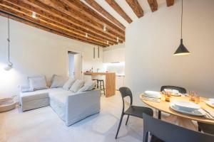 ein Wohnzimmer mit einem weißen Sofa und einem Tisch in der Unterkunft Grifalcon D'Oro - Centro Storico in Venedig