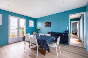 ル・トレポールにあるLe Domaine des pins - Maison 2 Chambres vue merの青い壁のダイニングルーム(テーブル、椅子付)