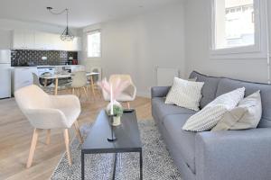 a living room with a gray couch and a table at Le Vitry - Appt 2 Chambres à 20min Orly in Vitry-sur-Seine