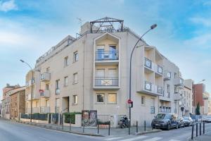 a tall white building with cars parked in front of it at Le Vitry - Appt 2 Chambres à 20min Orly in Vitry-sur-Seine