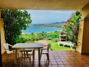 - une table et des chaises sur une terrasse avec vue sur l'océan dans l'établissement Appartamenti Spiaggia Bianca, à Golfo Aranci