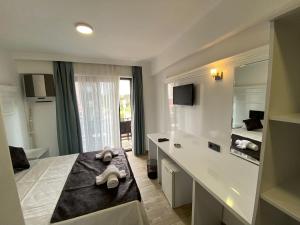 a bathroom with a bed and a sink and a mirror at ATAŞ AQUA OTEL AVŞA in Avşa Adası
