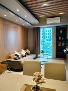 a living room with a couch and a table at The Asando Above Pakuwon Mall in Lontar